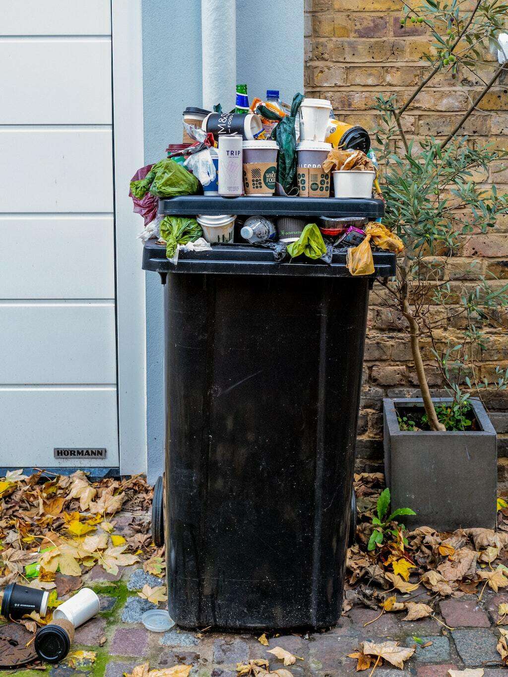 An overstuffed trash bin