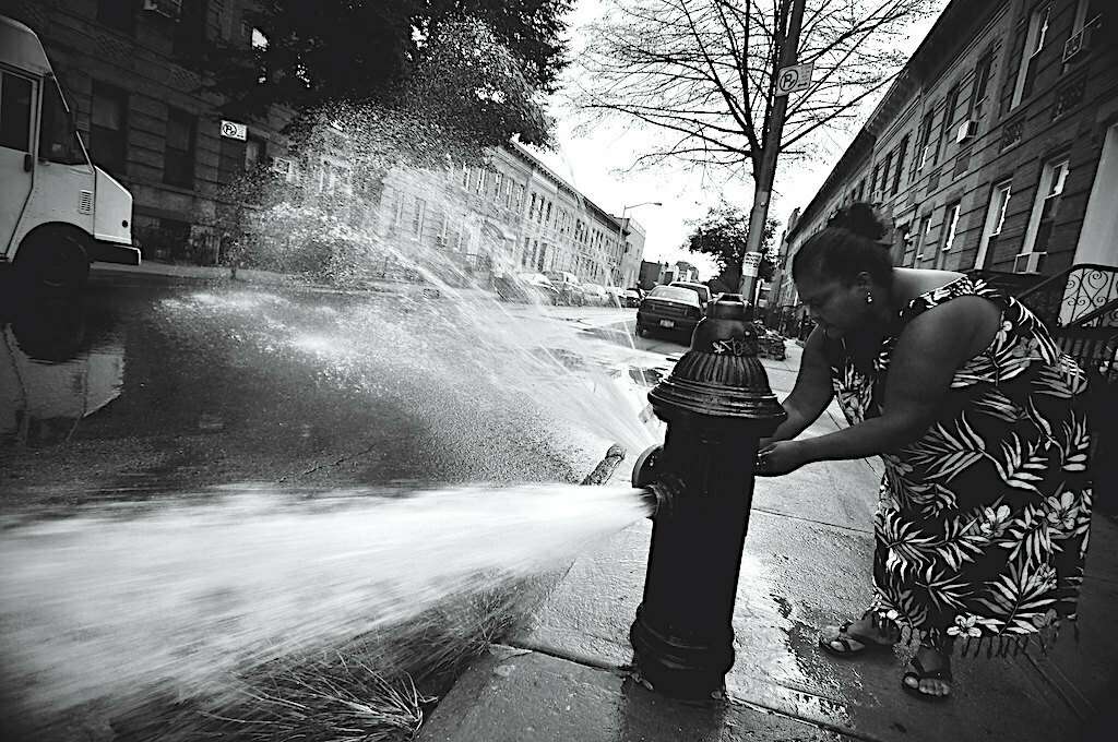 A New York woman finds relief from a heat wave in a street hydrant