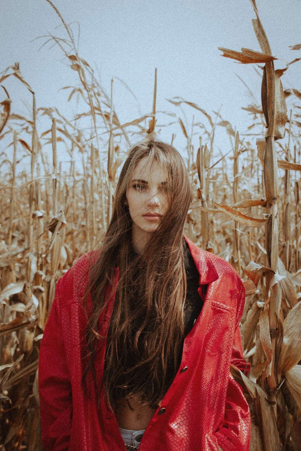 woman in red jacket in crop field