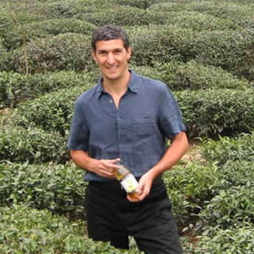Seth Goldman in a tea field with a bottle of Honest Tea