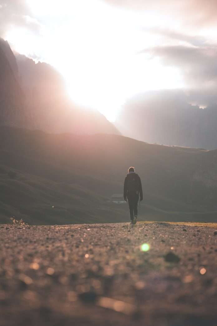 person walking toward mountain