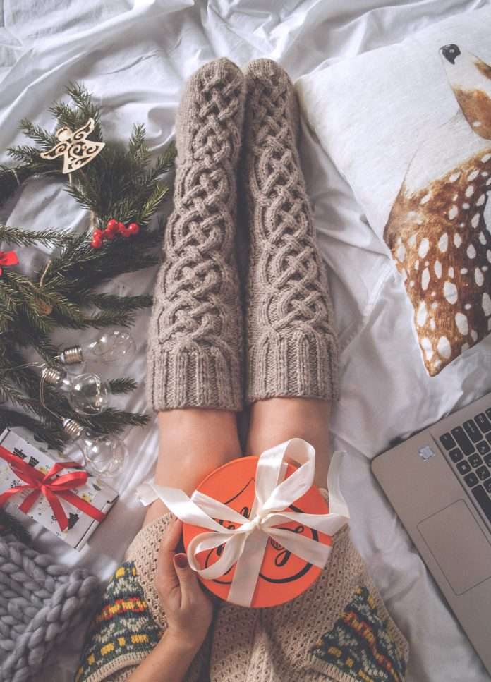 woman in socks surrounded by gifts