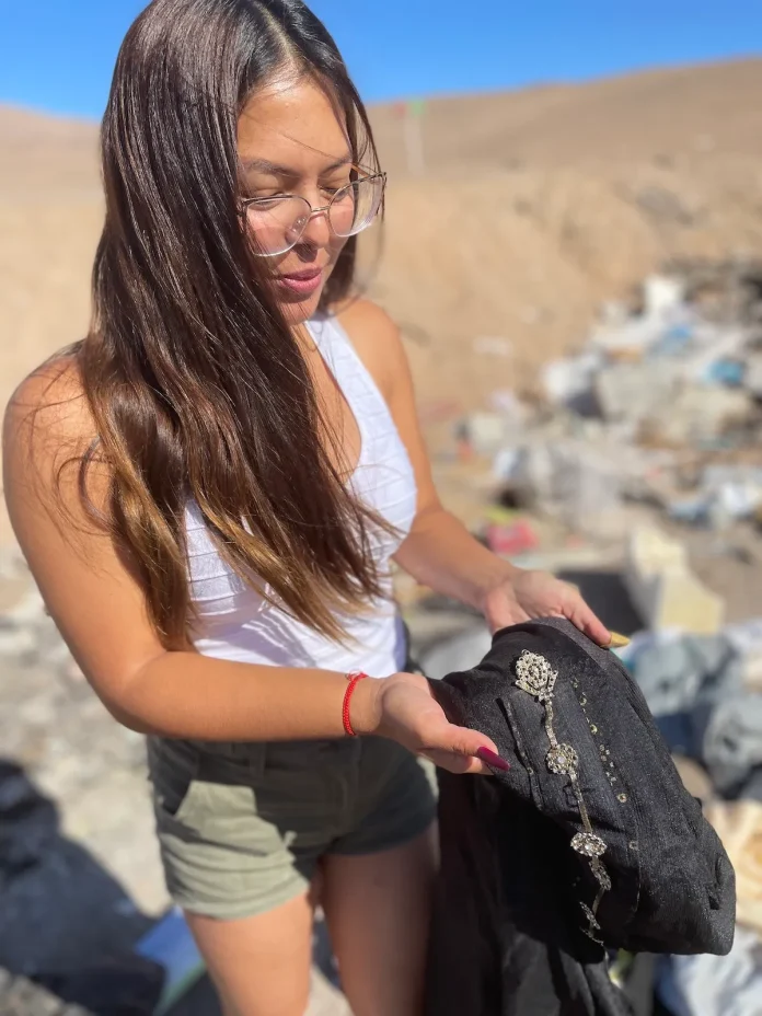 Ángela Astudilo holds a piece of discarded clothing from the Atacama Desert.