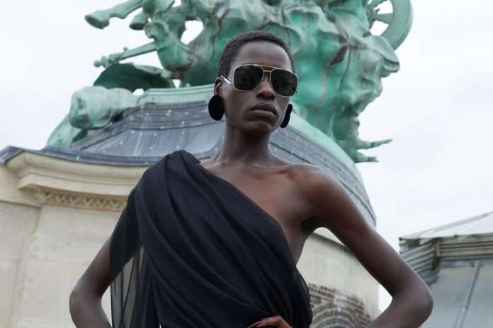 Saint Laurent model in black dress and glasses.